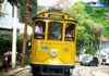 Exploring Rio’s Santa Teresa Yellow Cable Car on the cobblestone steets of Santa Teresa, Rio de Janeiro, Brazil.