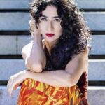 Marisa Monte’s 10 Favorite Brazilian Songs Marisa Monte's 10 favorite Brazilian songs: The Brazilian music star poses in a orange and yellow flame dress againsta wooden background