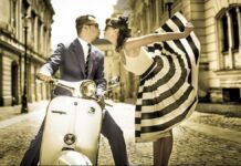From Italy To Bossa With Love From Italy To Bossa With Love. A well-dressed man kisses a flambouyant women wearing a stunning black and white sun dress hile sitting on a Vespa motorbike on an Italian cobblestone street.