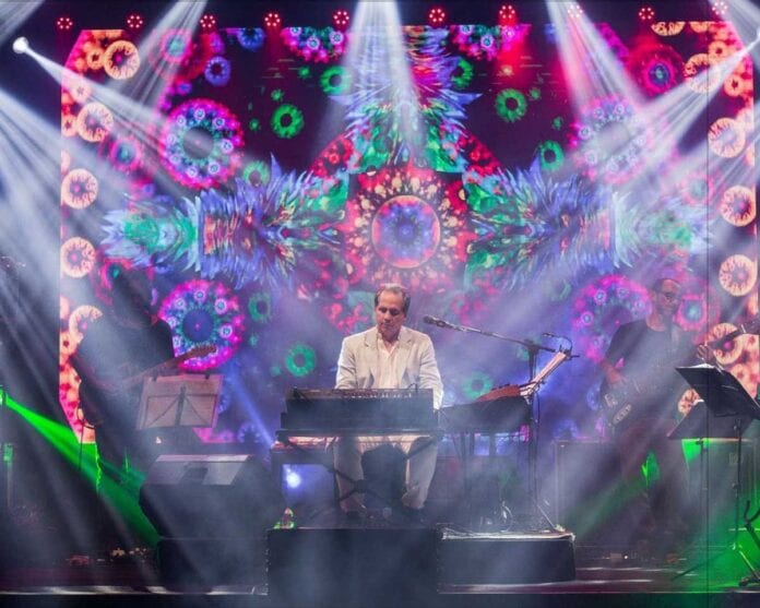 musician with keyboard amd colorful background with lights