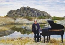 Brazilian pianist Ricardo Bacelar standing nest to grand paino in Ceara Brazil