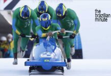 four people push a blue color3d bobseld at the winter olympic games