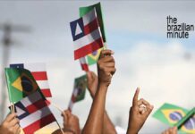 Celebrating Bahia's Independence Day with handheld flags for the state of Bahia and of Brazil.