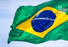 Brazil's National Flag waving in a clear blue sky.