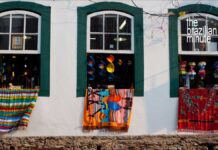 Experience Brazil’s World Heritage Sites. Colorful handmade rugs drape from open windows from the outside of a home in Ouro Preto Brazil.