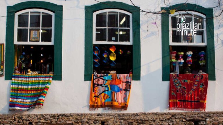 Experience Brazil’s World Heritage Sites. Colorful handmade rugs drape from open windows from the outside of a home in Ouro Preto Brazil.