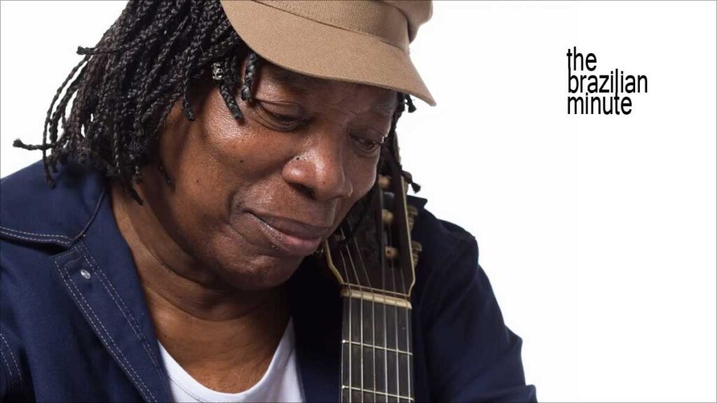 Milton Nascimento's Milestone Year. Nascimento wears his trademak tan cap while holding his guitar.