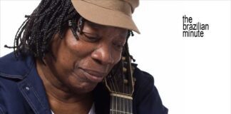 Milton Nascimento's Milestone Year. Nascimento wears his trademak tan cap while holding his guitar.