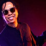 January's Brazilian Music Birthdays. Singer Djavan poses in dark long slves shirt and sunglasses.