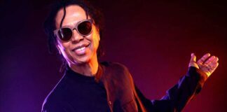 January's Brazilian Music Birthdays. Singer Djavan poses in dark long slves shirt and sunglasses.