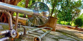 Roy Stephansen's musical move. Silver trombone sits on a stone bench surrounded by park-like greenery.