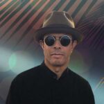 Gregory Abbotts Whisper The Words. The R&B singer wearing trendy sunglasses and stylish hat in front of a tropcial backdrop.