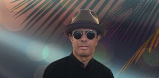 Gregory Abbotts Whisper The Words. The R&B singer wearing trendy sunglasses and stylish hat in front of a tropcial backdrop.