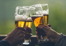 Brazil's craft beer primer. Four men toast with foamy golden ales in clear tall glasses