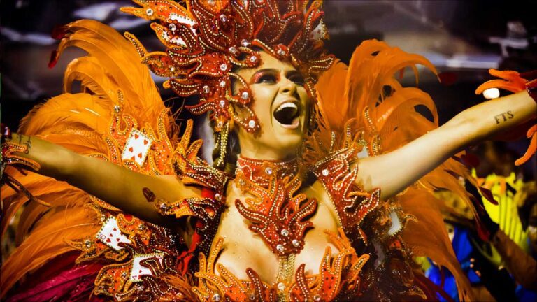Connect Brazil's Carnaval Coast-to-Coast guide gathers up the best - and most exciting - events. A Samba dancer in Orange feather ans red headdress celebrates at Carnaval in Brazil.